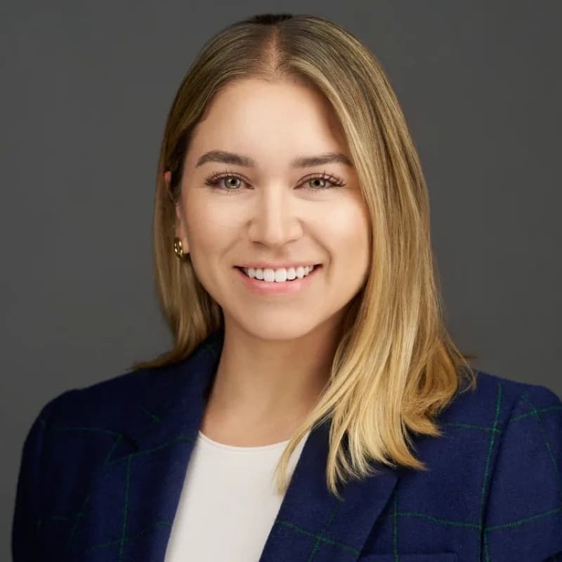 Ana Torres Rodriguez, smiling in a navy windowpane blazer