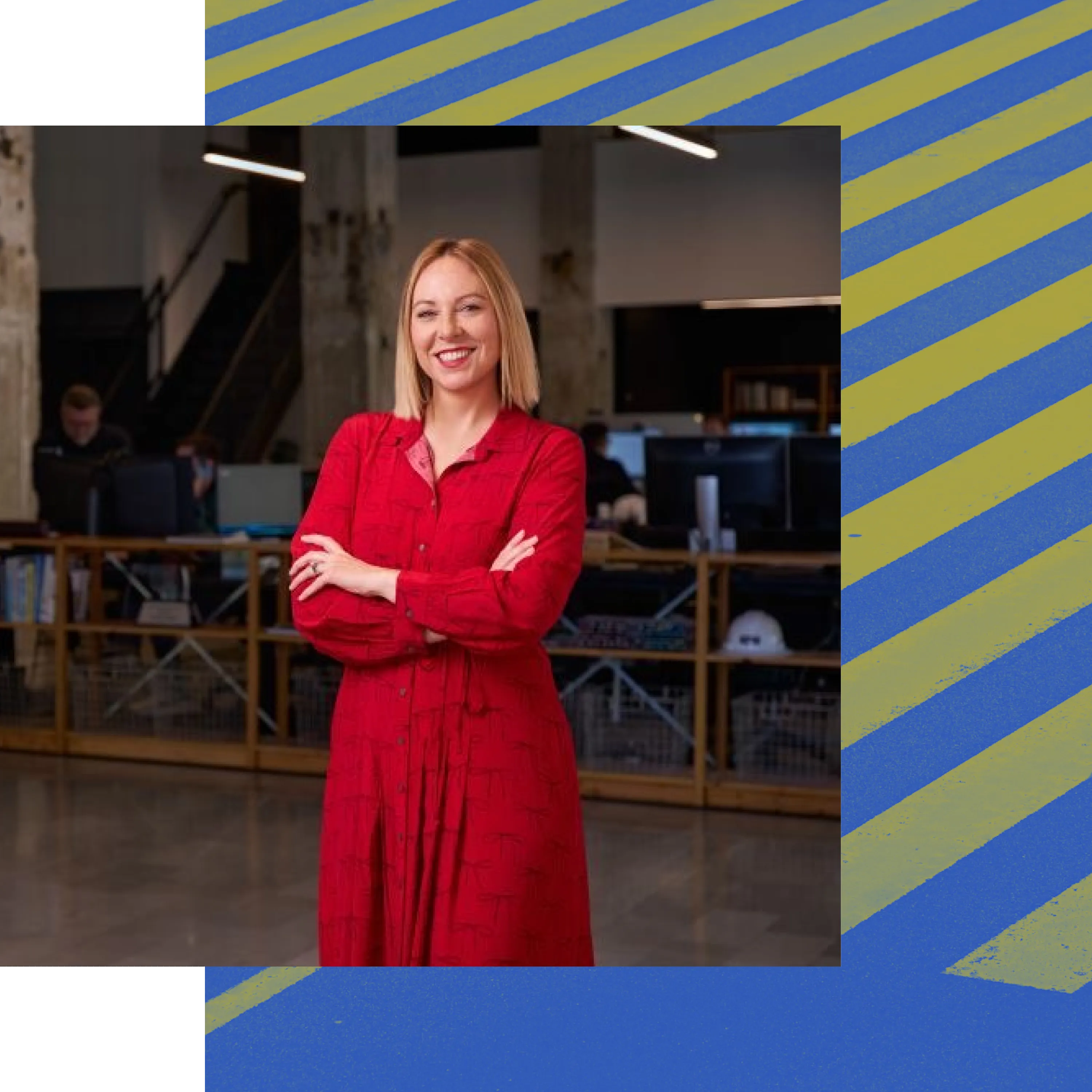 Whitney Stauffer of Narrate Design, smiling with arms crossed in an open office
